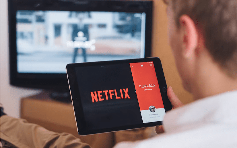 A Man sitting front of Netflix screen on his Tablet